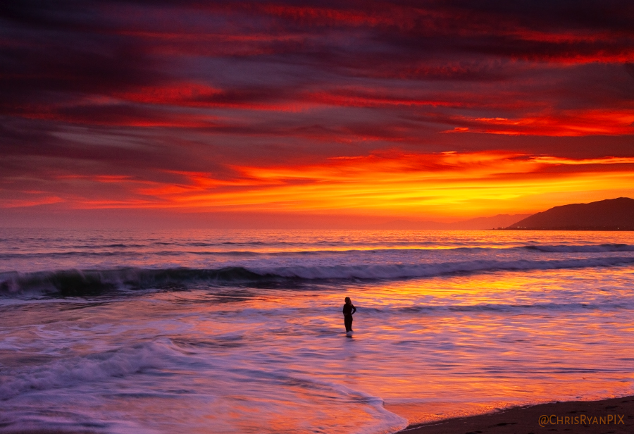 Surfer Standing on the Shoreline during Sunset watching waves