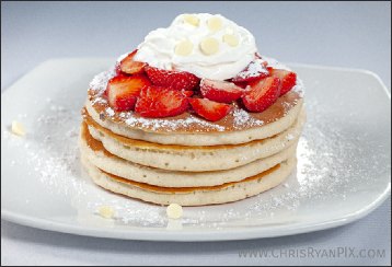 delicious stack of pancakes covered in strawberries